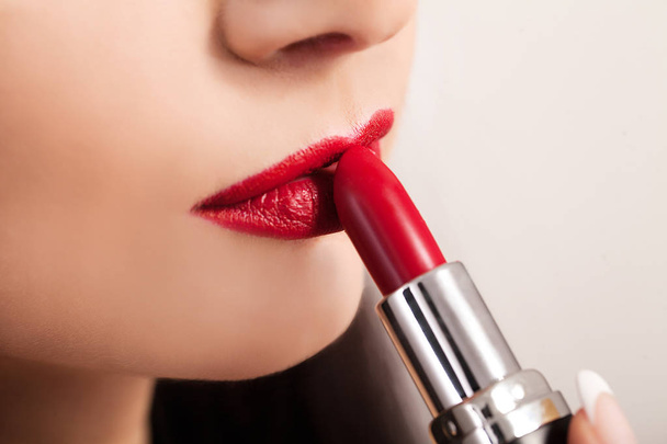 Belle femme peint les lèvres avec du rouge à lèvres. Belle visage de femme
. - Photo, image