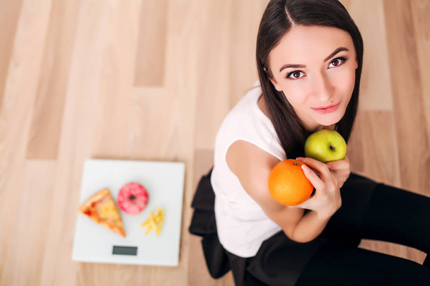 σπορ γυναίκα με κλίμακα και το πράσινο μήλο και πορτοκάλι - Φωτογραφία, εικόνα