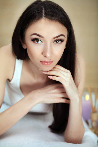 Cute young woman enjoying during a skin care treatment at a spa. - 写真・画像