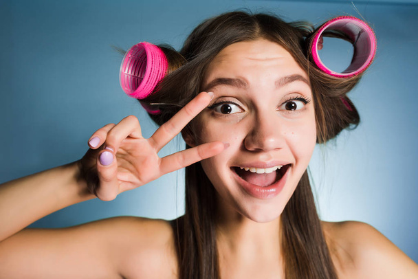 happy girl is going to walk, doing a haircut with a big curler, looks funny - Photo, Image