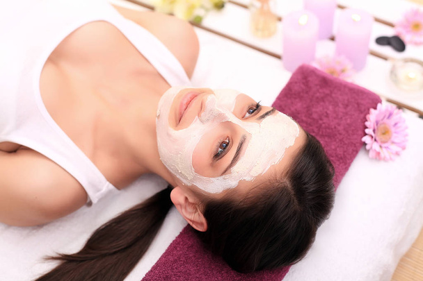 Spa therapie voor jonge vrouw gezichtsmasker gelet op de salon van de schoonheid - - Foto, afbeelding