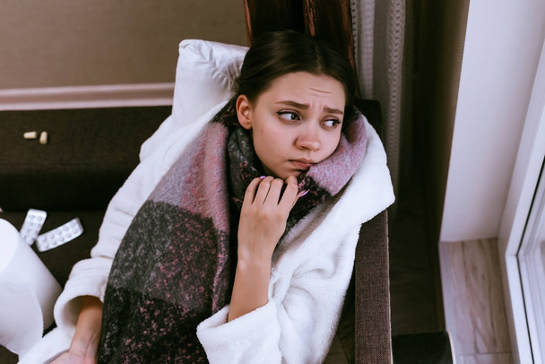 sad young girl fell ill with sore throat, on her throat scarf, because of the cold winter weather - Foto, Imagen