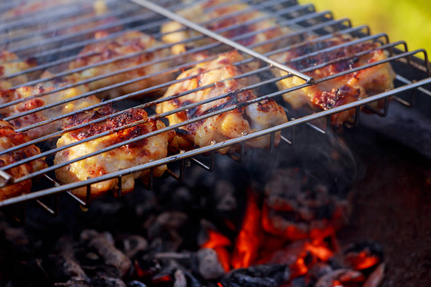 Grilled chicken leg over flames on a barbecue. - Photo, Image