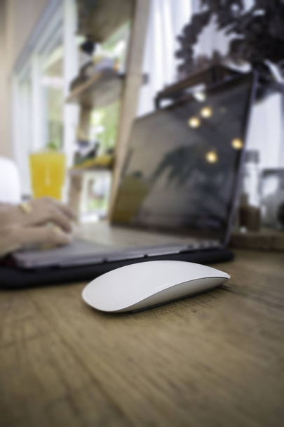 Nainen kannettavan tietokoneen ja appelsiinimehua pöydässä
 - Valokuva, kuva