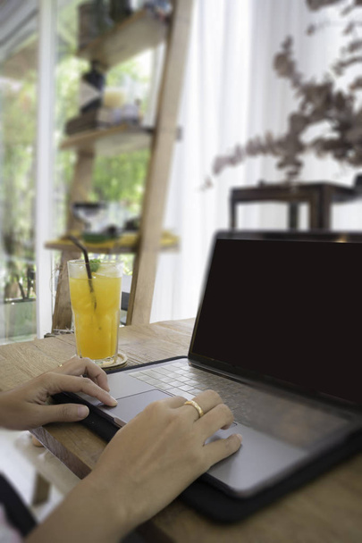 Nainen kannettavan tietokoneen ja appelsiinimehua pöydässä
 - Valokuva, kuva