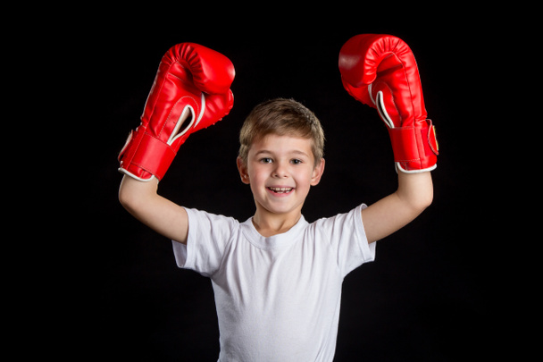 Petit boxeur extrêmement heureux et réussi avec les deux mains en haut dans des gants de boxe rouge
 - Photo, image