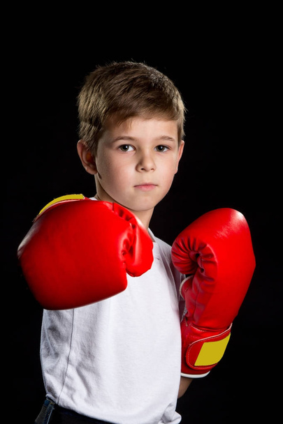 Confident serious boxer portrait. Straight attack kick in red boxing gloves - Photo, Image