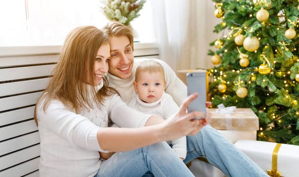 happy family photographed on phone, makes selfies in Christmas m - Photo, Image