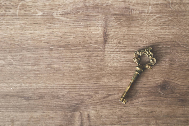 Vintage oude roestige sleutel op het houten bord - Foto, afbeelding