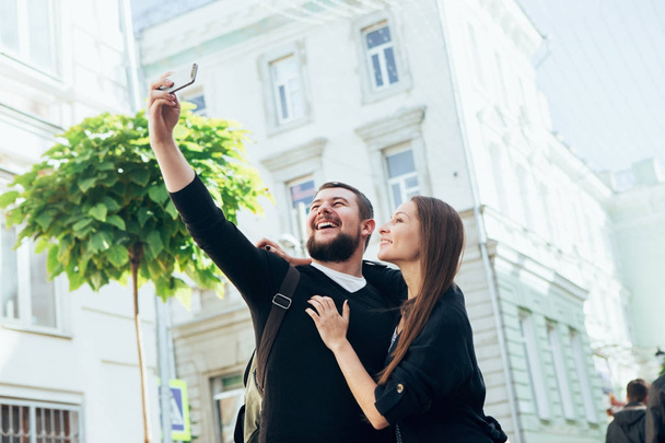 A loving couple of travelers do selfie on a city street.  - Фото, зображення