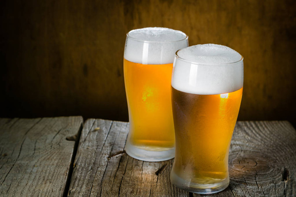 Bier in frostigen Bechern auf rustikalem Hintergrund - Foto, Bild