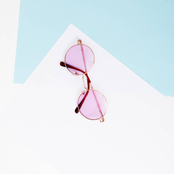 Stile minimale. Fotografia minimalista di moda. L'estate della moda sta arrivando. Occhiali rosa su sfondo pastello, vista dall'alto. Stile minimale alla moda con sfondo di carta colorato
 - Foto, immagini