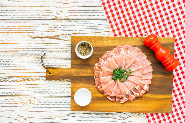 Fatia crua de carne de porco na placa de corte de madeira - Processamento de filetes
 - Foto, Imagem