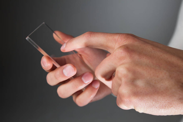 Hands holding futuristic transparent phone - Fotoğraf, Görsel