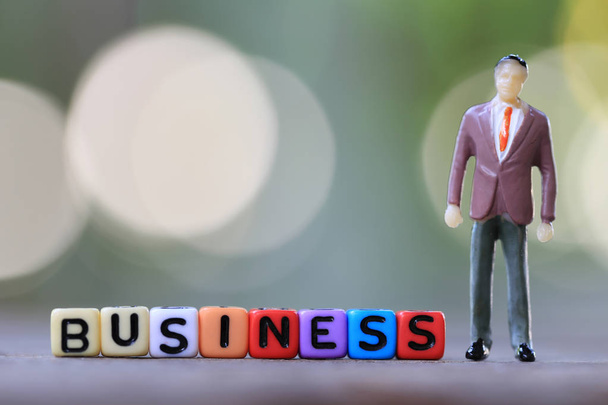 Бізнесмен лялька стоїть поруч з текстовою коробкою бізнесу
. - Фото, зображення