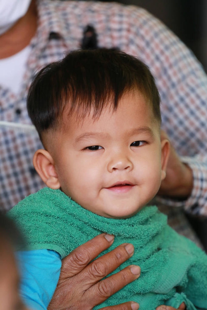 Aziatische jongen op een groen shirt in een kapper, concept van gezondheidszorg. - Foto, afbeelding