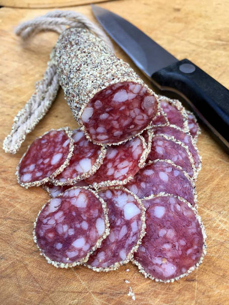 Plakjes salami met peper klaar om te eten in close-up - Foto, afbeelding