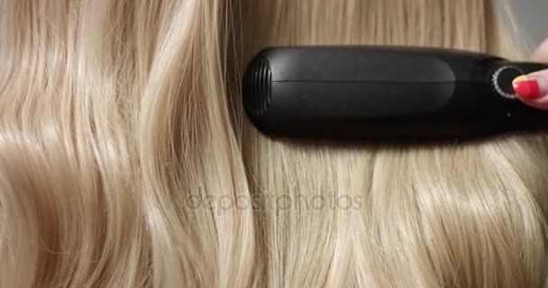 Styling blond hair with hair straightener - Footage, Video