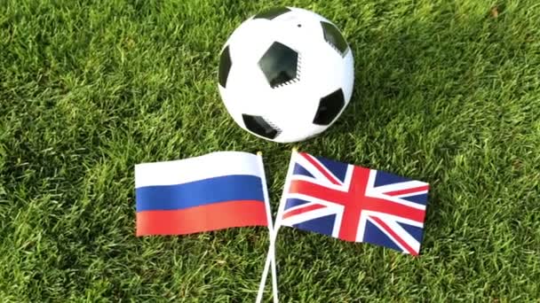 Fotbalový míč a vlajky Ruska a Velké Británie. Fotbalový míč v trávě, světa ve fotbale 2018. - Záběry, video