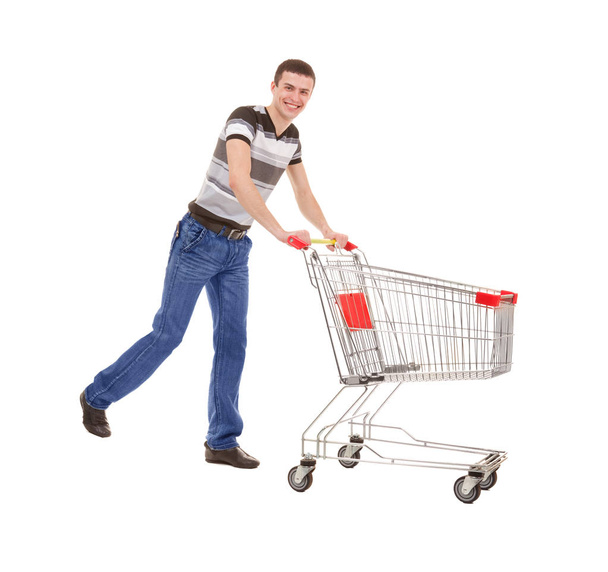 Young Man Running with Empty Shopping Cart on White Background - Фото, изображение