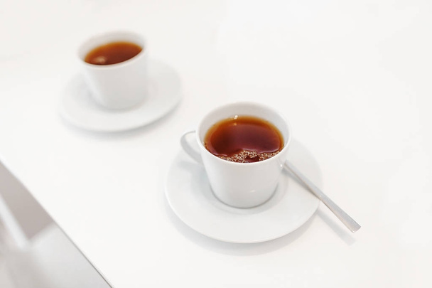 Дві чашки гарячого чаю на білому тлі, як концепція офісної перерви
 - Фото, зображення