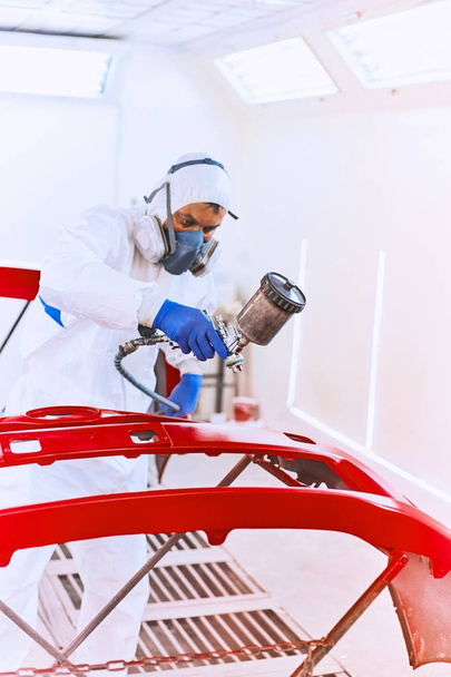 Painting bumpers machine red in the paint shop. - Photo, image