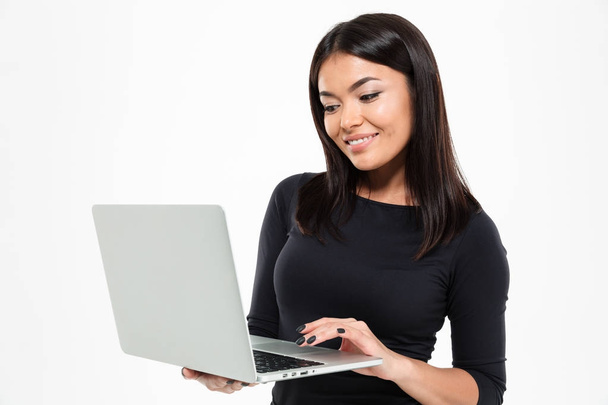 Cheerful young asian lady chatting by laptop computer - 写真・画像