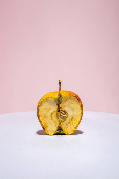 Old apple in a cut on a colored background - Фото, изображение