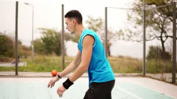 Man throwing basketball ball on court in park, slow motion shot - Záběry, video