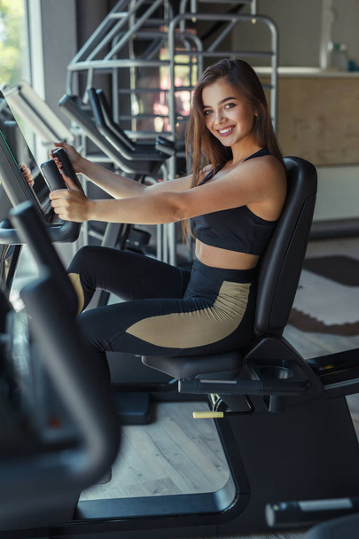 Smiling woman on gym machine - Photo, Image