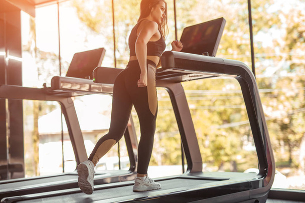 Sportswoman working on treadmill - 写真・画像