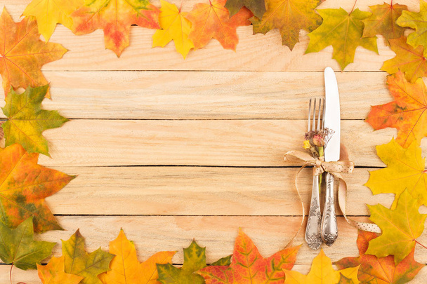 Cutlery in the frame made from maple leaves - Фото, изображение