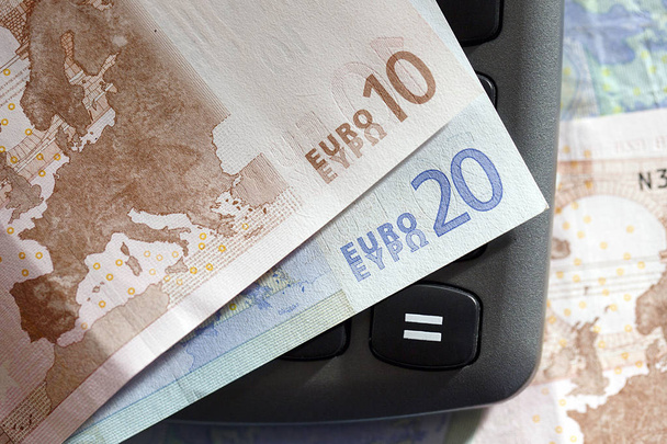 Europäische Währung - Zehn- und Zwanzig-Euro-Banknoten über einen Taschenrechner  - Foto, Bild