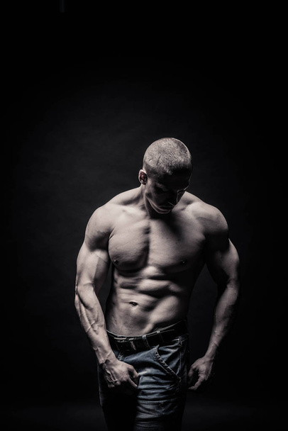 portrait of a male bodybuilder on a black background isolated. m - Foto, afbeelding