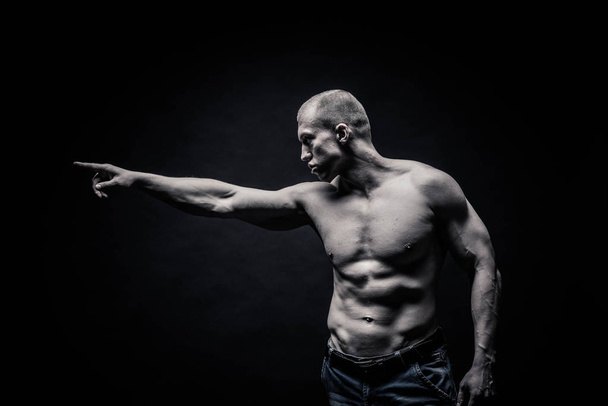 Portrait of a handsome male bodybuilder, on a black background i - Фото, изображение