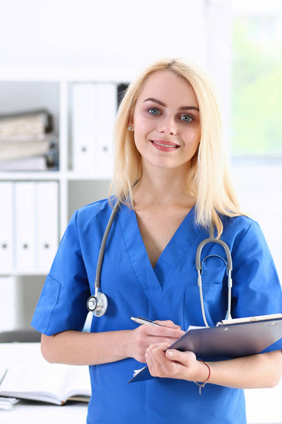 Kaunis hymyilevä naislääkäri seistä virassa
 - Valokuva, kuva