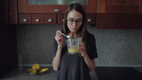 Meisje met bril eet ontbijt in de keuken. - Video