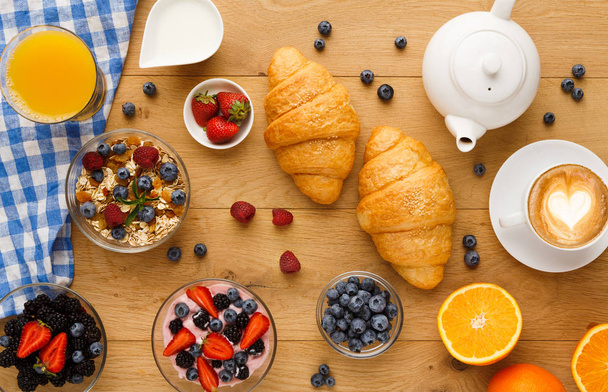 Continental breakfast with croissants and berries on natural wood - Photo, Image