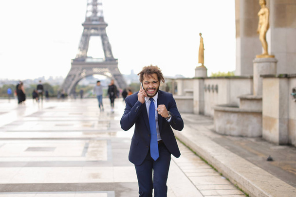 Jocund mulato chico delirando cerca de la Torre Eiffel y llamando amigo b
 - Foto, imagen