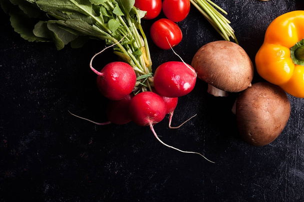Over bovenkant close-up van verschillende groenten op donkere tafel - Foto, afbeelding