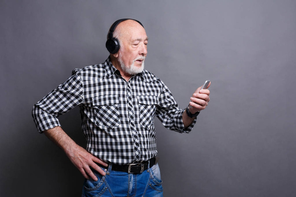 Senior man listening to music with headphones - Photo, image