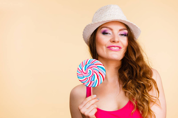 Woman holds colorful lollipop candy in hand - Valokuva, kuva