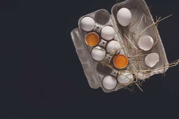 Fresh brown eggs in carton on black background - Photo, Image