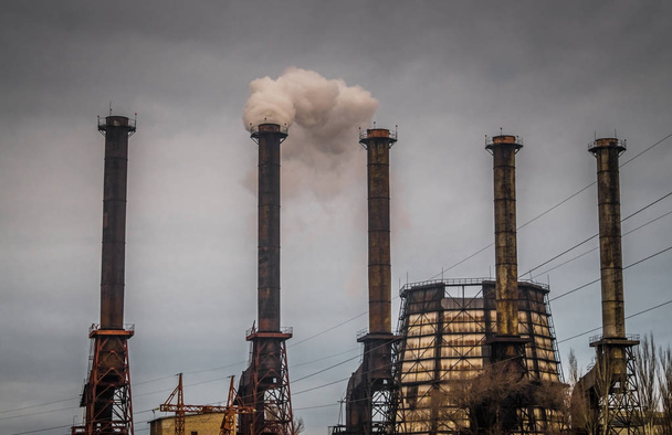 Distruzione dell'ambiente. Fumaioli di un impianto chimico. tubo di fumo di fabbrica sullo sfondo di un cielo grigio cupo. Emissioni chimiche nocive nell'atmosfera. Inquinamento ambientale e riscaldamento globale
 - Foto, immagini