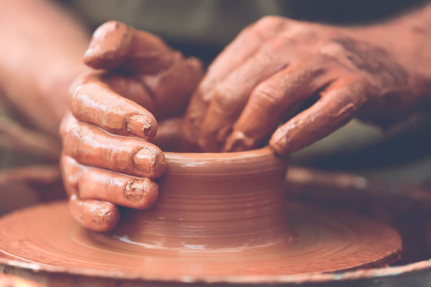 Potter making ceramic pot on the pottery wheel - Фото, изображение