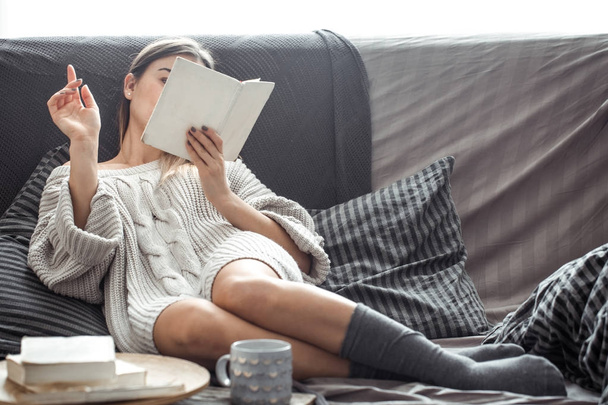 girl reading book on sofa - Foto, imagen