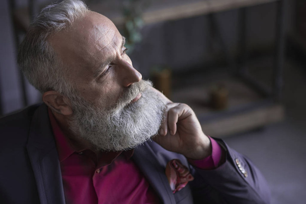 Pensive bearded grandfather locating in room - Fotografie, Obrázek