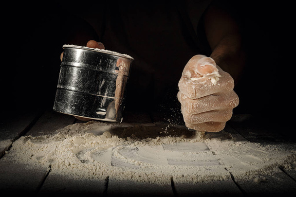 Cook adding flour from cup - Foto, Bild