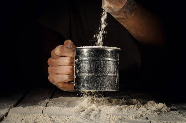 Cook adding flour from cup - Foto, Imagen