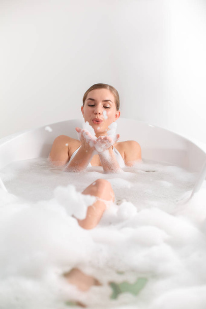 Carefree girl playing with bubbles in bath - Foto, Imagen